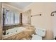 Well-lit bathroom with a tub, shower, and stone-look tile at 6315 Eldora Ave, Las Vegas, NV 89146