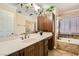 Bathroom features a double sink vanity, soaking tub with shower, and decorative finishes at 6315 Eldora Ave, Las Vegas, NV 89146