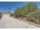 Long driveway leading to a detached garage and a home surrounded by mature trees and landscaping at 6315 Eldora Ave, Las Vegas, NV 89146