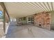Spacious covered patio features brick fireplace, concrete flooring and exterior views of landscaping and blue sky at 6315 Eldora Ave, Las Vegas, NV 89146