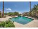 Backyard pool with lush green landscaping, tall palm trees and blue sky perfect for summertime activities at 6315 Eldora Ave, Las Vegas, NV 89146