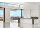 Modern kitchen featuring white cabinets, a waterfall island with marble accents, and city views at 641 Majestic Rim Dr, Henderson, NV 89012