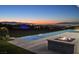Incredible outdoor view featuring a pool, fire pit, and vibrant city lights at dusk at 641 Majestic Rim Dr, Henderson, NV 89012