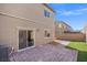 Backyard featuring patio with stone pavers, grassy area, and the exterior of the house at 7051 Denio Island St, North Las Vegas, NV 89084