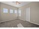 Neutral bedroom with ceiling fan, carpet, and bright natural light from multiple windows at 7051 Denio Island St, North Las Vegas, NV 89084
