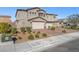 Charming stucco two-story home with a brick driveway and well-maintained landscaping at 7051 Denio Island St, North Las Vegas, NV 89084