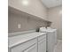 Laundry room with a large white countertop, white cabinets, and washer and dryer at 7051 Denio Island St, North Las Vegas, NV 89084