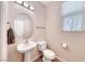 Clean half-bath with a pedestal sink, updated fixtures, and a well-lit vanity mirror at 708 Point Bluff St, Henderson, NV 89002
