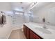 Bathroom featuring a tub/shower combo, cherry wood vanity with a sink, and a large mirror at 708 Point Bluff St, Henderson, NV 89002