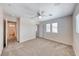 Spacious carpeted bedroom with multiple windows, a ceiling fan, and a glimpse of a hallway at 708 Point Bluff St, Henderson, NV 89002