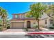 Two-story home with a well-manicured lawn, brick driveway, and mature landscaping, located in a quiet neighborhood at 708 Point Bluff St, Henderson, NV 89002