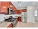 Eat-in kitchen featuring stainless steel appliances, wood cabinets, tile floors, and gray counter tops at 708 Point Bluff St, Henderson, NV 89002