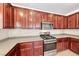 Gourmet kitchen featuring wood cabinetry, stainless steel appliances and spacious gray counter tops at 708 Point Bluff St, Henderson, NV 89002