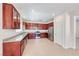 Well-lit kitchen with dark wood cabinets, stainless steel appliances, and tile floors at 708 Point Bluff St, Henderson, NV 89002