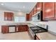 Modern kitchen with stainless steel appliances, wood cabinets, tile floors and natural lighting at 708 Point Bluff St, Henderson, NV 89002