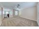 Spacious living room featuring neutral carpet, a ceiling fan, and plenty of natural light at 708 Point Bluff St, Henderson, NV 89002