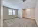 Well-lit living room with plush carpeting, neutral walls, and access to the front door at 708 Point Bluff St, Henderson, NV 89002