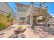 Covered patio with outdoor kitchen featuring a stone fire pit and built-in grill at 708 Point Bluff St, Henderson, NV 89002