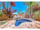 Beautiful backyard pool with rock waterfall and lush tropical landscaping creating a private oasis at 708 Point Bluff St, Henderson, NV 89002