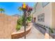 Landscaped side yard with a wall, walkway, plants, and a decorative torch under a bright blue sky at 708 Point Bluff St, Henderson, NV 89002