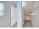 Walk-in closet with installed shelving and a carpeted floor just off of the laundry room at 708 Point Bluff St, Henderson, NV 89002