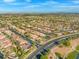 Expansive aerial view showcasing a neighborhood with well-maintained homes, tile roofs, and mature landscaping at 7411 Brittlethorne Ave, Las Vegas, NV 89131