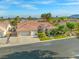Wide aerial shot of the house with desert landscaping, a three car garage and well maintained exterior at 7411 Brittlethorne Ave, Las Vegas, NV 89131