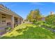 Lush backyard featuring a well-maintained lawn, mature trees, and a covered patio, perfect for outdoor entertaining at 7411 Brittlethorne Ave, Las Vegas, NV 89131
