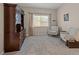 Inviting bedroom featuring two sitting chairs and a large storage cabinet at 7411 Brittlethorne Ave, Las Vegas, NV 89131