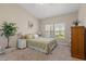 Comfortable bedroom features carpet flooring, a large window, and neutral paint at 7411 Brittlethorne Ave, Las Vegas, NV 89131