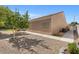 Back exterior view of home featuring a desert landscape design, neutral stucco walls and an air conditioning unit at 7411 Brittlethorne Ave, Las Vegas, NV 89131