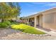 Well-maintained front yard featuring a lush lawn, stone-edged flower beds, and a covered patio, enhancing curb appeal at 7411 Brittlethorne Ave, Las Vegas, NV 89131