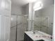 Bathroom showcasing a shower with glass doors, white vanity, and large mirror at 75 N Valle Verde Dr # 411, Henderson, NV 89074