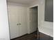 A hallway with wood-look flooring, double closets, and grey cabinets with white countertop at 75 N Valle Verde Dr # 411, Henderson, NV 89074