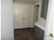 A hallway with wood-look flooring, double closets, and grey cabinets with white countertop at 75 N Valle Verde Dr # 411, Henderson, NV 89074