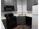 Modern kitchen showcasing black appliances, gray cabinets, and wood-style flooring at 75 N Valle Verde Dr # 411, Henderson, NV 89074