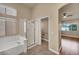 Bright bathroom featuring a tub and separate glass-enclosed shower at 7824 Faith Ct, Las Vegas, NV 89131