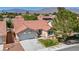 Inviting single-story home with a red tile roof, manicured lawn, desert landscaping, and a two car garage at 7824 Faith Ct, Las Vegas, NV 89131