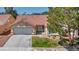 Charming single-story home featuring a terra cotta roof, a two-car garage, and a well-manicured front lawn at 7824 Faith Ct, Las Vegas, NV 89131
