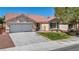 Attractive single-story home with a terra cotta roof, a well-kept lawn, and an attached two-car garage at 7824 Faith Ct, Las Vegas, NV 89131