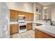 Bright kitchen features white appliances, white backsplash, wooden cabinets and tile floors at 7824 Faith Ct, Las Vegas, NV 89131