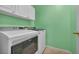 This laundry room has a full-sized washer and dryer with upper cabinets for storage at 7824 Faith Ct, Las Vegas, NV 89131