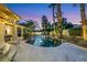 Backyard with a gorgeous swimming pool, mature palm trees, ambient lighting, and lush landscaping at 8224 Fawn Meadow Ave, Las Vegas, NV 89149