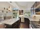 Spacious kitchen featuring granite countertops, stainless steel appliances, dark wood cabinetry, and sliding glass doors to patio at 8224 Fawn Meadow Ave, Las Vegas, NV 89149