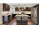 Well-equipped kitchen featuring granite countertops, stainless steel appliances, dark wood cabinets, and center island with stools at 8224 Fawn Meadow Ave, Las Vegas, NV 89149