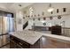Kitchen island with granite countertop, dark wood cabinets, and stainless steel refrigerator adjacent to the living room at 8224 Fawn Meadow Ave, Las Vegas, NV 89149