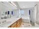 Bright bathroom featuring double sinks, a large mirror, a soaking tub, and a glass-enclosed shower at 8481 Lambert Dr, Las Vegas, NV 89147