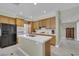 Well-lit kitchen with wood cabinetry, tiled island, and black appliances at 8481 Lambert Dr, Las Vegas, NV 89147