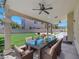 Covered outdoor patio with ceiling fan, glass table, and chairs overlooking landscaped backyard at 8481 Lambert Dr, Las Vegas, NV 89147