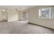 Sunlit living room featuring neutral carpet, a window view, and patio access at 8600 W Charleston Blvd # 1128, Las Vegas, NV 89117